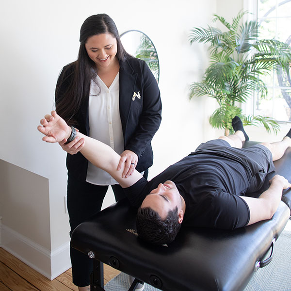 physician taking providing physical therapy to male patient