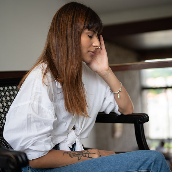 Young woman with headache at home